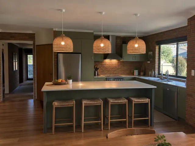 Three woven pendant lights above a kitchen island in a brick-and-timber home interior in Glenning Valley